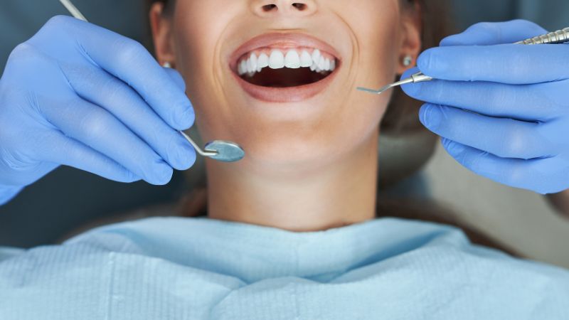 Dentist cleaning teeth during procedure