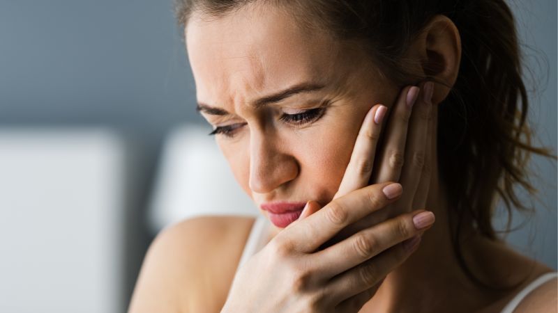 Woman holding mouth indicating soreness
