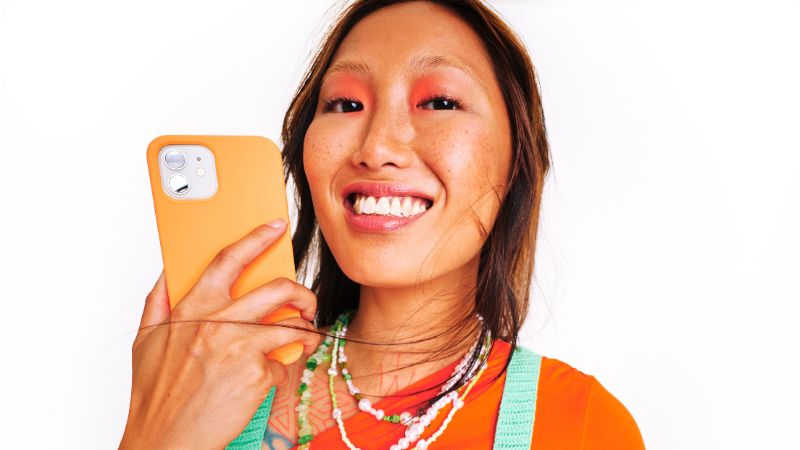 Asian woman with phone smiling